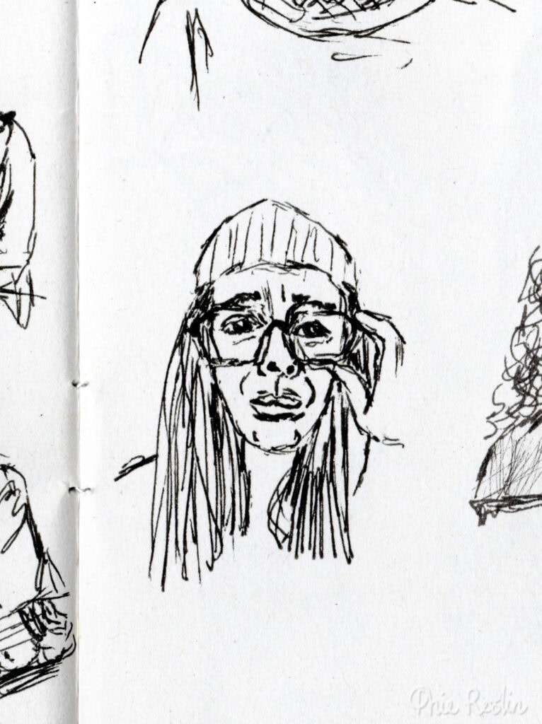 Pen sketch self portrait of worried looking face wearing glasses and holding them in left hand.